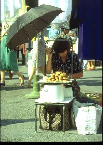Verkauft wurde alles, was nicht niet-und nagelfest war. Hier ein Einmannmarktstand mit Sonnenschirm. Es wird Brot verkauft.